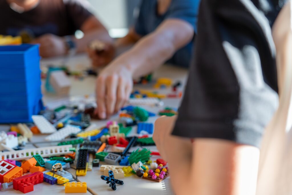 Hand greift nach Lego-Steinen